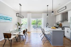 a white kitchen with a dining table and chairs at Woodberry in Nashville