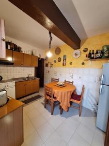Il comprend une cuisine équipée d'une table, de chaises et d'un réfrigérateur. dans l'établissement A Casa da Nonna Brasa Holiday Home Savoca, à Savoca