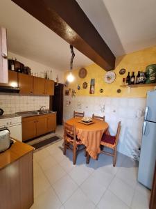 a kitchen with a table with chairs and a refrigerator at A Casa da Nonna Brasa Holiday Home Savoca in Savoca