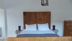 a bed with a wooden headboard and two white pillows at Superking Size City Centre En-Suite Room + Parking in Preston