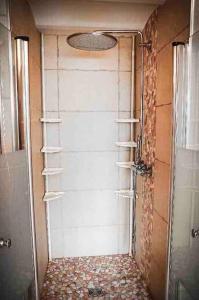 y baño con ducha y puerta blanca. en Gîte avec Sauna et Hammam privatif - 1000 étangs, en Moffans-et-Vacheresse