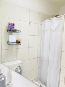 a white bathroom with a shower curtain and a sink at Espacio Edison 1 in Santa Rosa