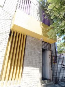 a building with yellow columns on the side of it at Marbelo Pernambuco Hostel in Recife