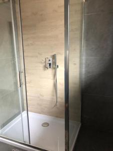 a shower with a glass door in a bathroom at U Biela in Poronin