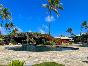 einen Pool inmitten eines Resorts mit Palmen in der Unterkunft Kauai Beach Resort Room 2401 in Lihue