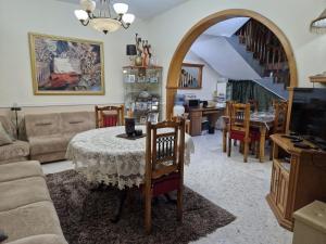 - un salon avec une table et des chaises ainsi qu'un escalier dans l'établissement Saracini's Homestay - 156, Emerald, à Attard