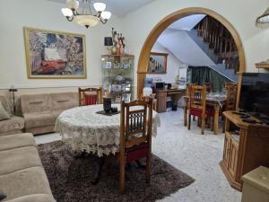 a living room with a table and chairs and a staircase at Saracini's Homestay in Attard