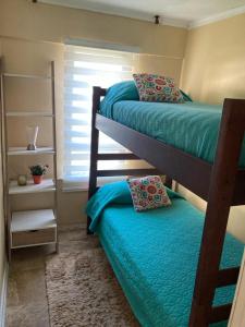 a bedroom with two bunk beds and a window at Acogedor Departamento amoblado Viña del Mar Poniente 2D 1B in Viña del Mar