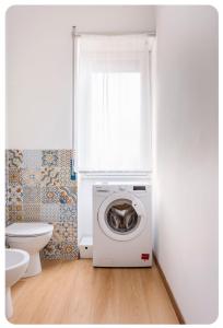 y baño con aseo y lavadora. en Casa Rizzoli - bilocale vicinissimo M2, en Milán