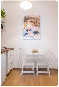 cocina con mesa blanca y 2 sillas en Casa Rizzoli - bilocale vicinissimo M2, en Milán
