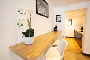 a dining room table with white chairs and a vase of flowers at Hidden Retreat with Steam room, KING bed near tube in London