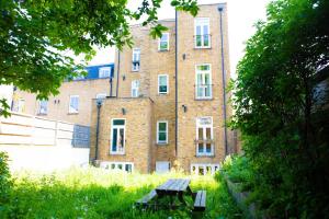 a bench in the grass in front of a building at Hidden Retreat with Steam room, KING bed near tube in London