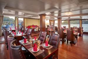 un restaurante en un crucero con mesas y sillas en Lotus Luxury Cruise, en Ha Long