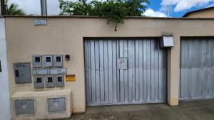 ゴイアニアにあるQuitinete Ar Condicionado WIFI Garagem Individualの門と機械二台の建物