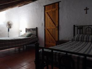 1 Schlafzimmer mit 2 Betten und einer Holztür in der Unterkunft Casa de campo en tafi del valle in San Miguel de Tucumán