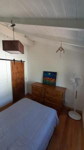ein Schlafzimmer mit einem Bett, einer Kommode und einer Lampe in der Unterkunft Casa Azul a 5 cuadras del centro y a 8 del mar in Villa Gesell