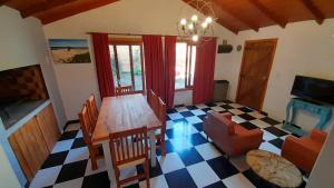 ein Esszimmer mit einem Tisch und einem Schachbrettboden in der Unterkunft Casa Azul a 5 cuadras del centro y a 8 del mar in Villa Gesell