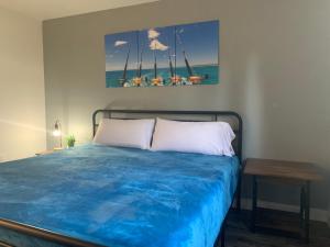Un dormitorio con una cama con sábanas azules y una mesa. en Brownsville Motel en Brownsville