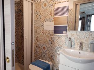 a bathroom with a sink and a toilet and a mirror at Villa Bella Sera in Scilla