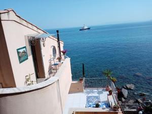 a balcony with a view of the ocean and a ship at Villa Bella Sera in Scilla