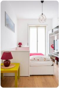 Casa Rizzoli - bilocale vicinissimo M2 في ميلانو: غرفة نوم بسرير وطاولة مع مصباح
