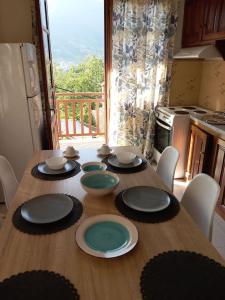 a wooden table with plates and bowls on top of it at Casa Luminosa in Metsovo