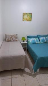 dos camas sentadas una al lado de la otra en una habitación en Cozinha Equipada em Apartamento para Alugar em Torres RS, en Torres