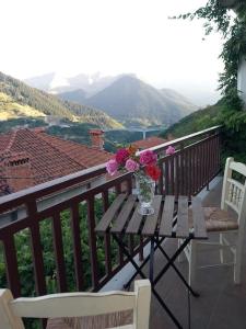 un jarrón de flores sentado en una mesa en un balcón en Casa Luminosa, en Metsovo