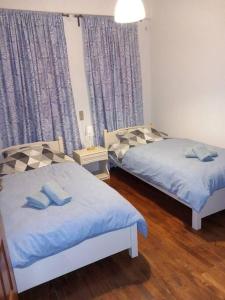 2 camas en una habitación con sábanas azules en Casa Luminosa, en Metsovo