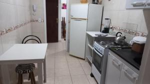 una pequeña cocina con fogones y nevera. en Cozinha Equipada em Apartamento para Alugar em Torres RS, en Torres