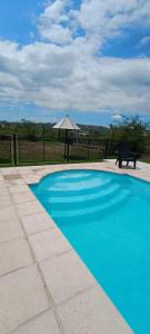 波特雷羅德洛斯弗內斯的住宿－Cabañas La Delfina，一个带桌子和遮阳伞的蓝色游泳池