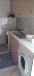 a kitchen with a washing machine and a sink at Home garden and big parking in Tripoli
