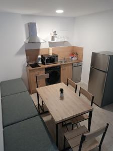 eine Küche mit einem Holztisch und eine Küche mit einem Kühlschrank in der Unterkunft Apartamentos turisticos Ávila Puerta de San Isidro 1-4 in Avila