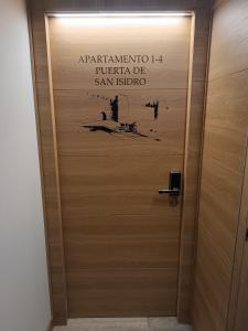 eine hölzerne Fahrstuhltür mit Schild drauf in der Unterkunft Apartamentos turisticos Ávila Puerta de San Isidro 1-4 in Avila