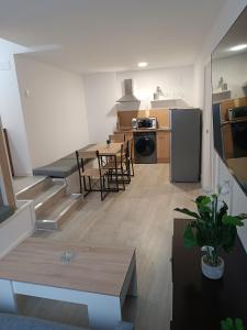 eine Küche und ein Wohnzimmer mit einem Tisch und einem Kühlschrank in der Unterkunft Apartamentos turisticos Ávila Puerta de San Isidro 1-4 in Avila