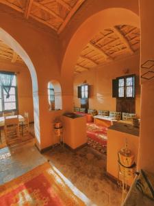 Cette grande chambre est dotée de murs orange et d'un plafond voûté. dans l'établissement Kasbah Ennakb, à Nkob
