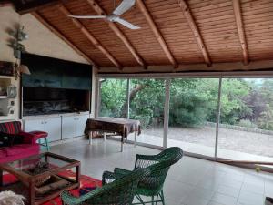 uma sala de estar com uma ventoinha de tecto e cadeiras em Casa de campo en tafi del valle em San Miguel de Tucumán