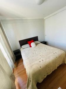 a bedroom with a bed with two pillows on it at Casa Piacenza, Cerca De Mall y Faro La Serena in La Serena