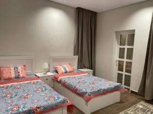 a bedroom with two beds and a window at شاليه رحال in Yanbu Al Bahr