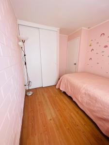 Un dormitorio con una cama rosa y una lámpara en Casa Piacenza, Cerca De Mall y Faro La Serena, en La Serena