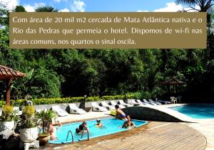 un grupo de personas en una piscina en un complejo en Hotel da Cachoeira, en Penedo