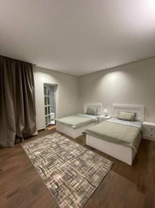 a bedroom with two beds and a rug at شاليه رحال in Yanbu Al Bahr