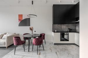 a kitchen and dining room with a table and chairs at FORUM apart in Lviv