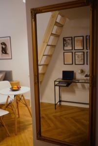 a mirror in a room with a table and a staircase at Art Apartment Bydgoszcz in Bydgoszcz