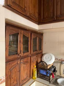 a wooden cabinet above a sink in a kitchen at Appartement meublé sans vis à vis proche de toutes commodités 5 min à Marjane chaikh Zaid et centre ville in Khouribga