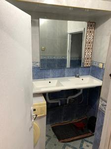 a bathroom with a sink and a mirror at Appartement meublé sans vis à vis proche de toutes commodités 5 min à Marjane chaikh Zaid et centre ville in Khouribga