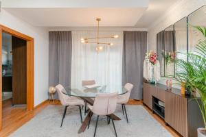 a dining room with a glass table and pink chairs at Quarto Brejos-Azeitão in Aldeia Rica