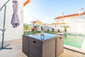 a patio with a table and a swimming pool at Quarto Brejos-Azeitão in Aldeia Rica