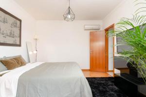 a bedroom with a bed and a potted plant at Quarto Brejos-Azeitão in Aldeia Rica