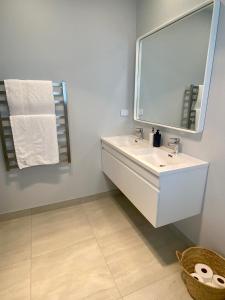 uma casa de banho com um lavatório branco e um espelho. em Coatesville Country Retreat em Auckland